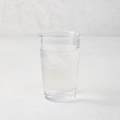Jacob Scissor-Cut Glass Tumbler, 8 oz., clear, thick air-blown glass with rippled rim, filled with water and ice.