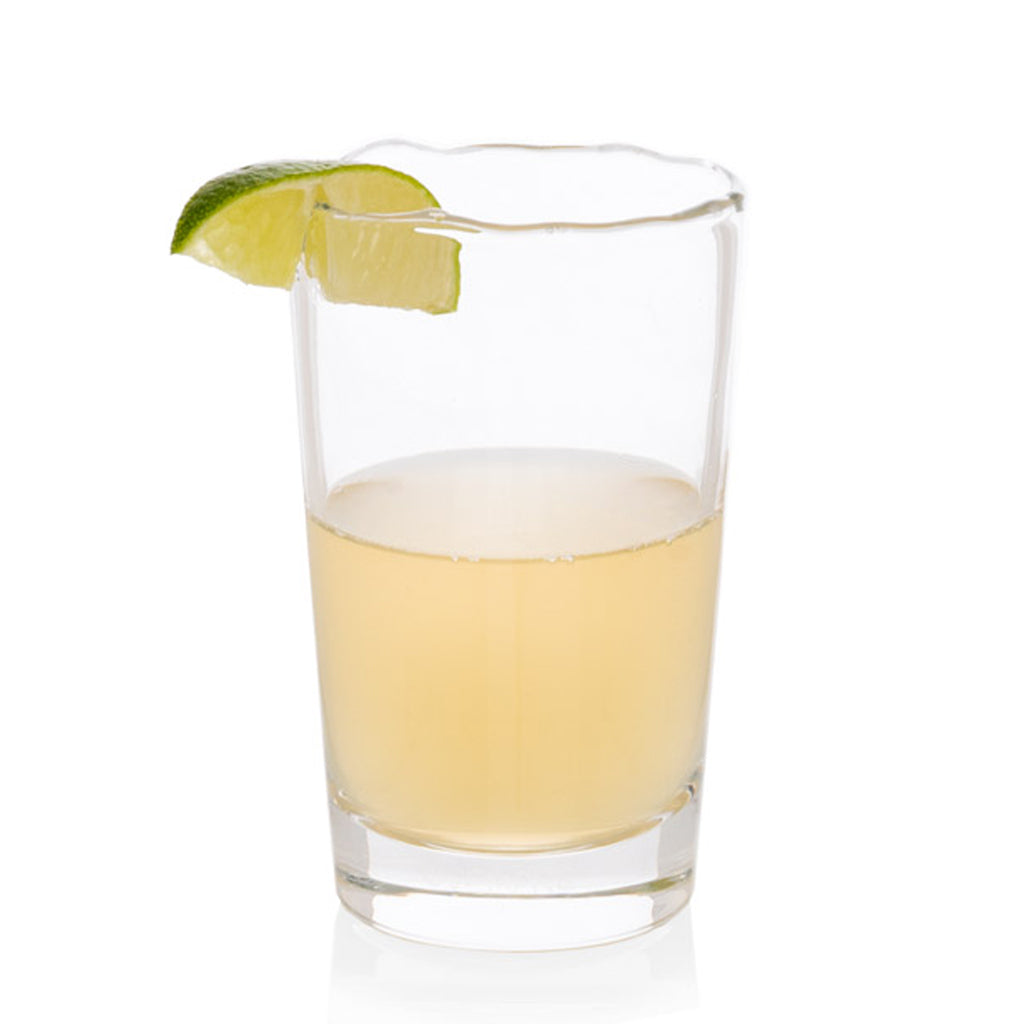 Jacob Scissor-Cut Glass Tumbler, 8 oz., clear with rippled rim, holding a light yellow drink and lime wedge.