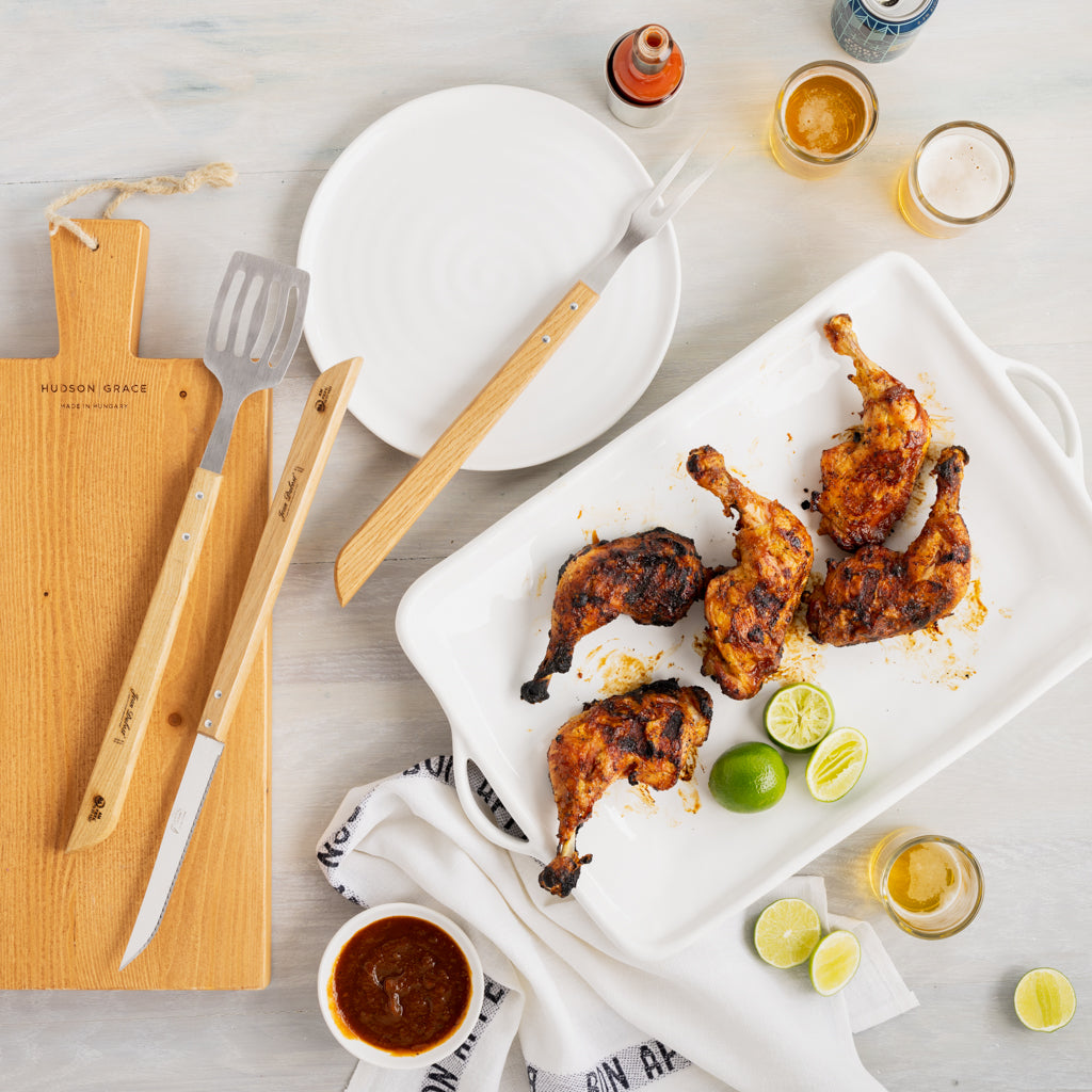 Jean Dubost 3-piece BBQ tool set: stainless steel knife, fork, spatula with light wood handles on a cutting board.