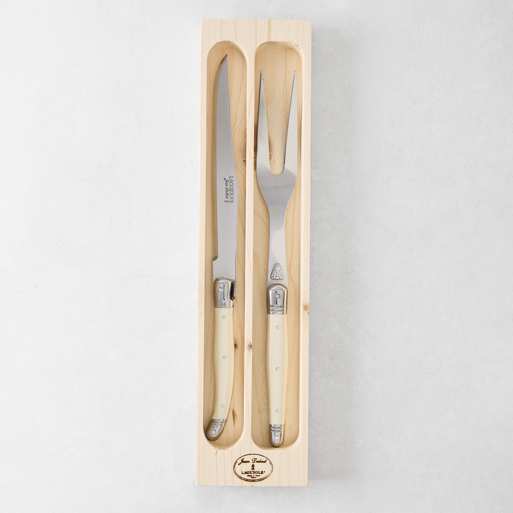 Jean Dubost Laguiole carving set: stainless steel knife and fork with ivory handles in a wooden box.