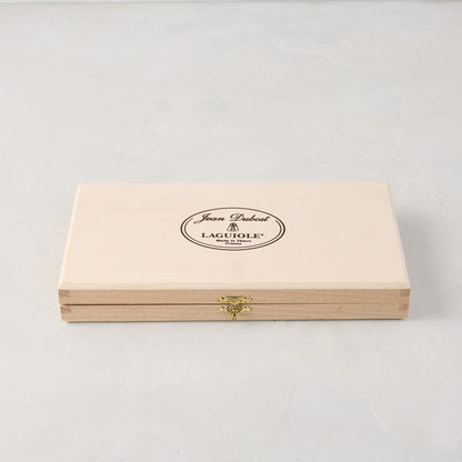 Jean Dubost Laguiole stainless steel table knives set in a light wooden storage box with a gold clasp.