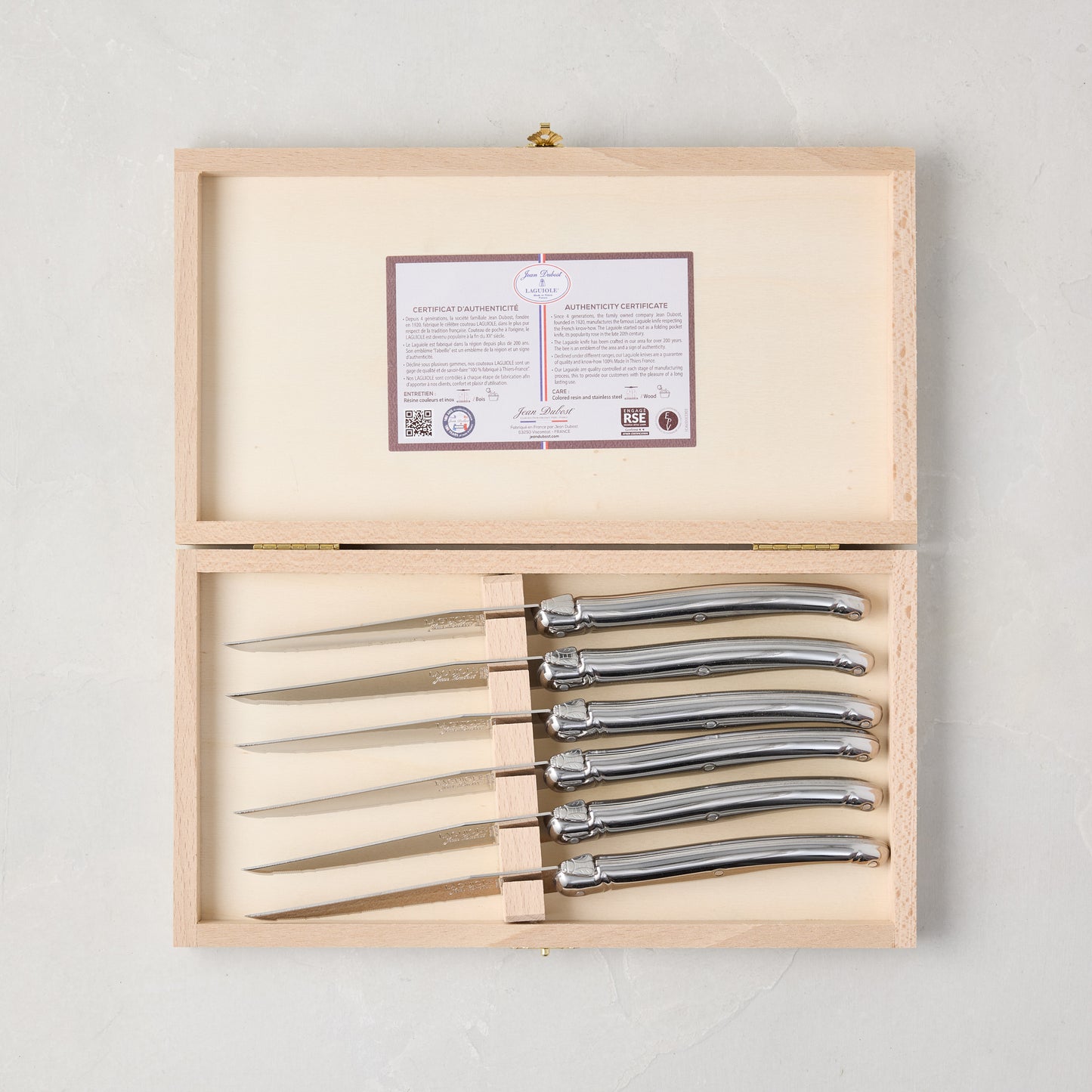Jean Dubost Laguiole stainless steel table knives, set of 6, in an open light wood storage box with authenticity certificate.