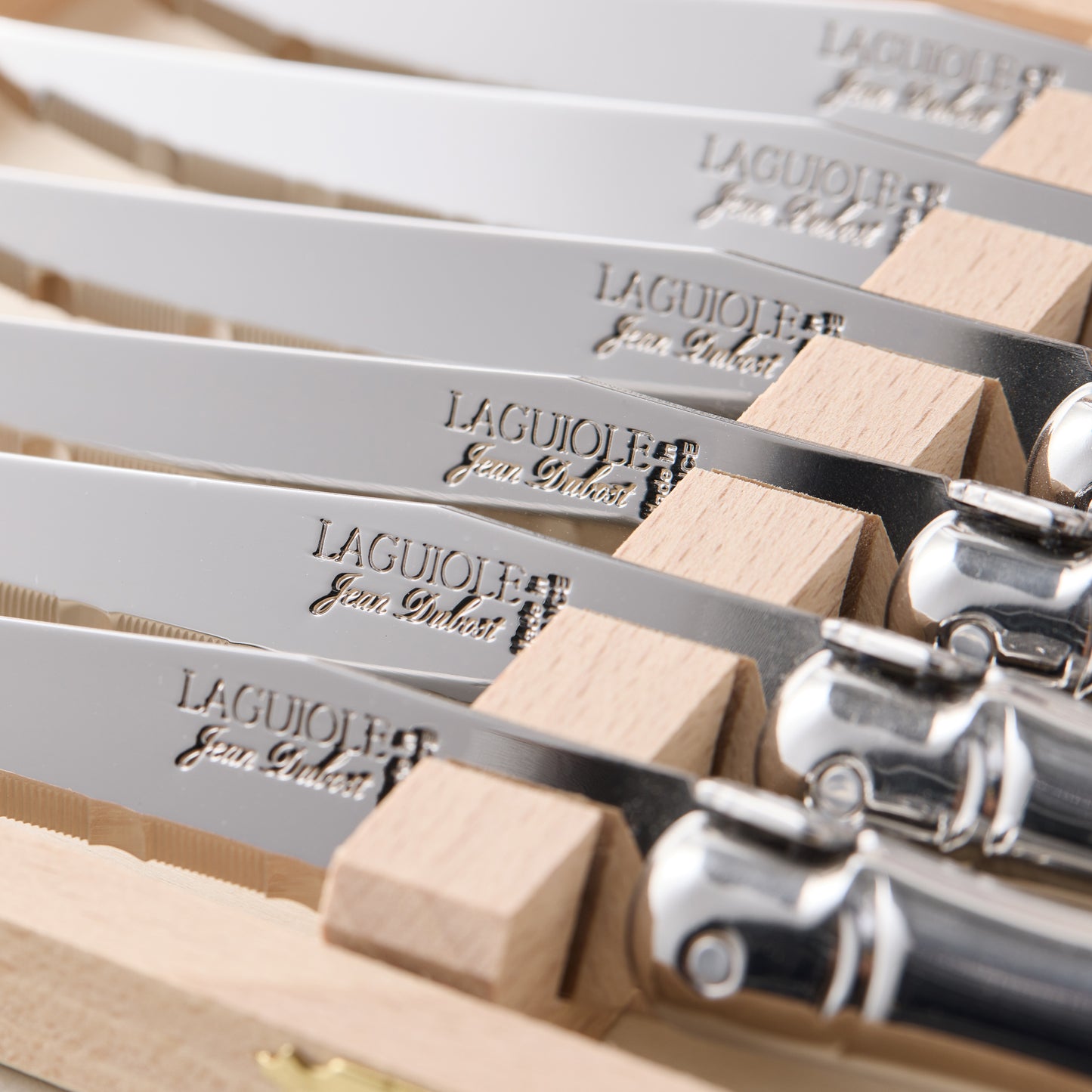 Jean Dubost Laguiole stainless steel table knives, set of 6, with light wood handles in a wooden storage box.