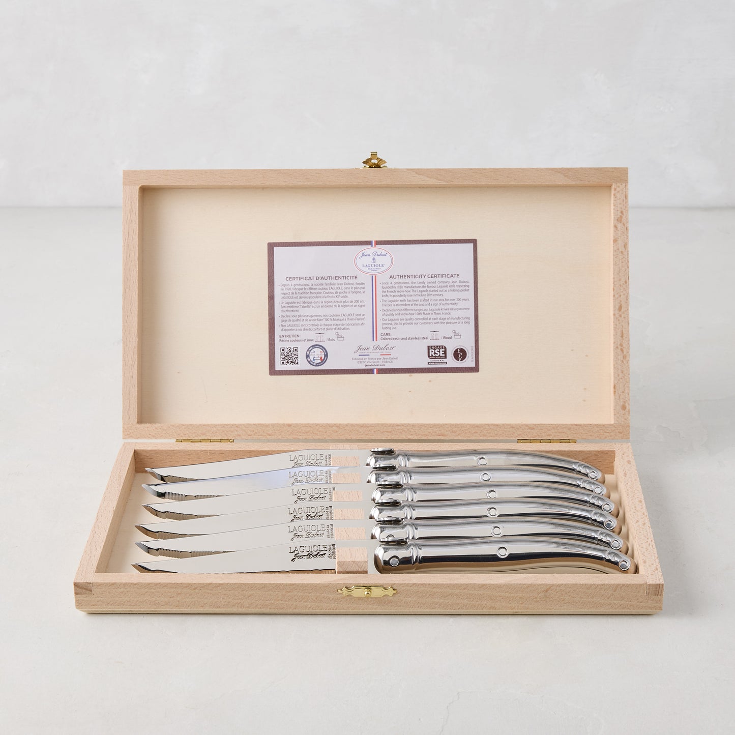 Jean Dubost Laguiole stainless steel table knives, set of 6, in an open wooden storage box with certificate.