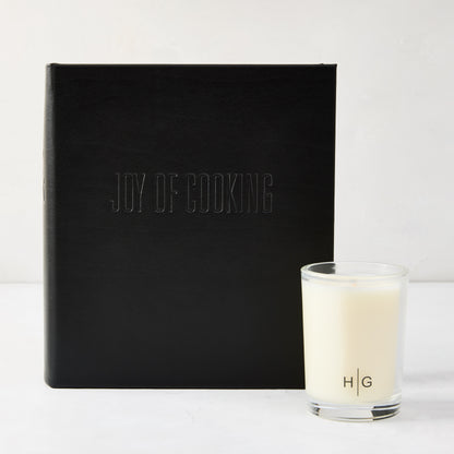 Black leather "Joy of Cooking" cookbook with blind embossed title, next to a Hudson Grace Kitchen candle.