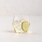 Clear glass Juniper double old fashioned glass with a geometric silhouette, filled with ice and a lime slice.