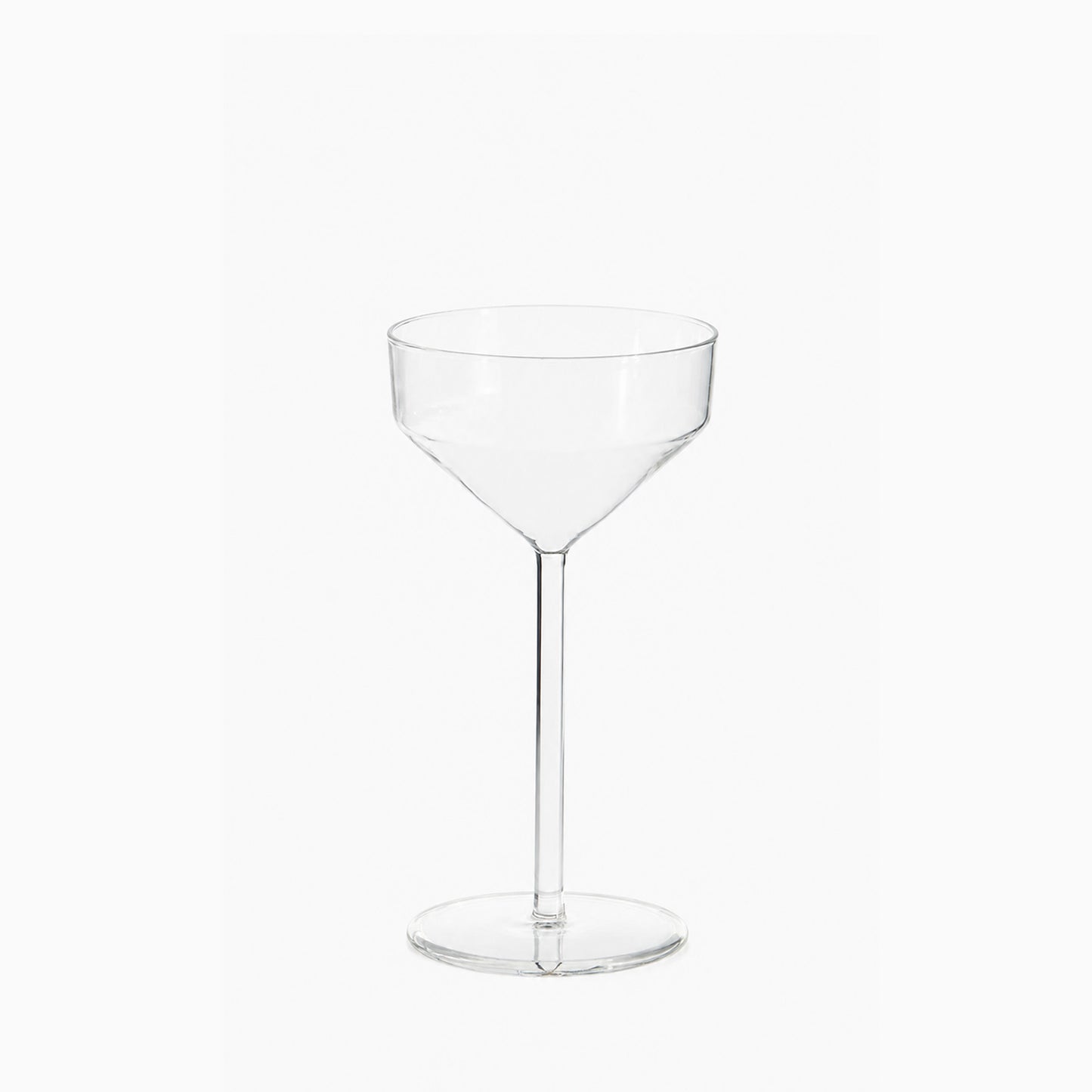 Clear glass Juniper cocktail coupe with a modern, geometric silhouette and a tall, slender stem on a white background.