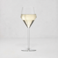 A clear glass wine glass with a wide bowl, a tapered middle section, and a long stem, shown on a light gray studio background. The glass is partially filled with a pale golden liquid.