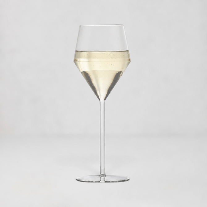 A clear glass wine glass with a wide bowl, a tapered middle section, and a long stem, shown on a light gray studio background. The glass is partially filled with a pale golden liquid.