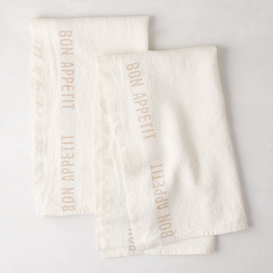 Set of 2 khaki linen hand towels with "BON APPETIT" text, folded on a white surface.
