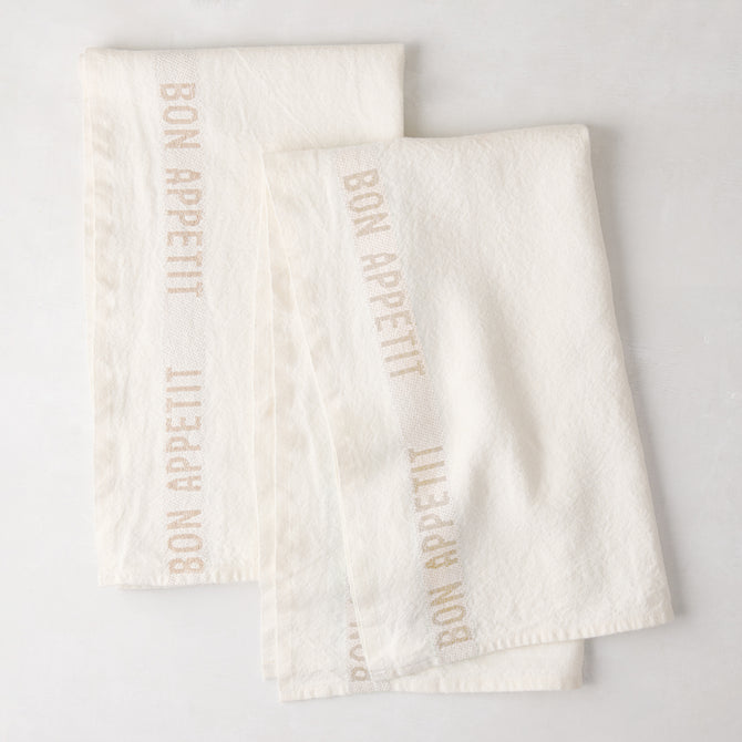 Set of 2 khaki linen hand towels with "BON APPETIT" text, folded on a white surface.