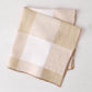 Khaki buffalo check linen napkin, 20x20, folded on a white surface.