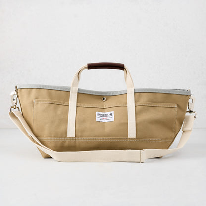 Khaki canvas garden tote bag with olive green exterior, grey interior, brown leather grips, and long shoulder strap.