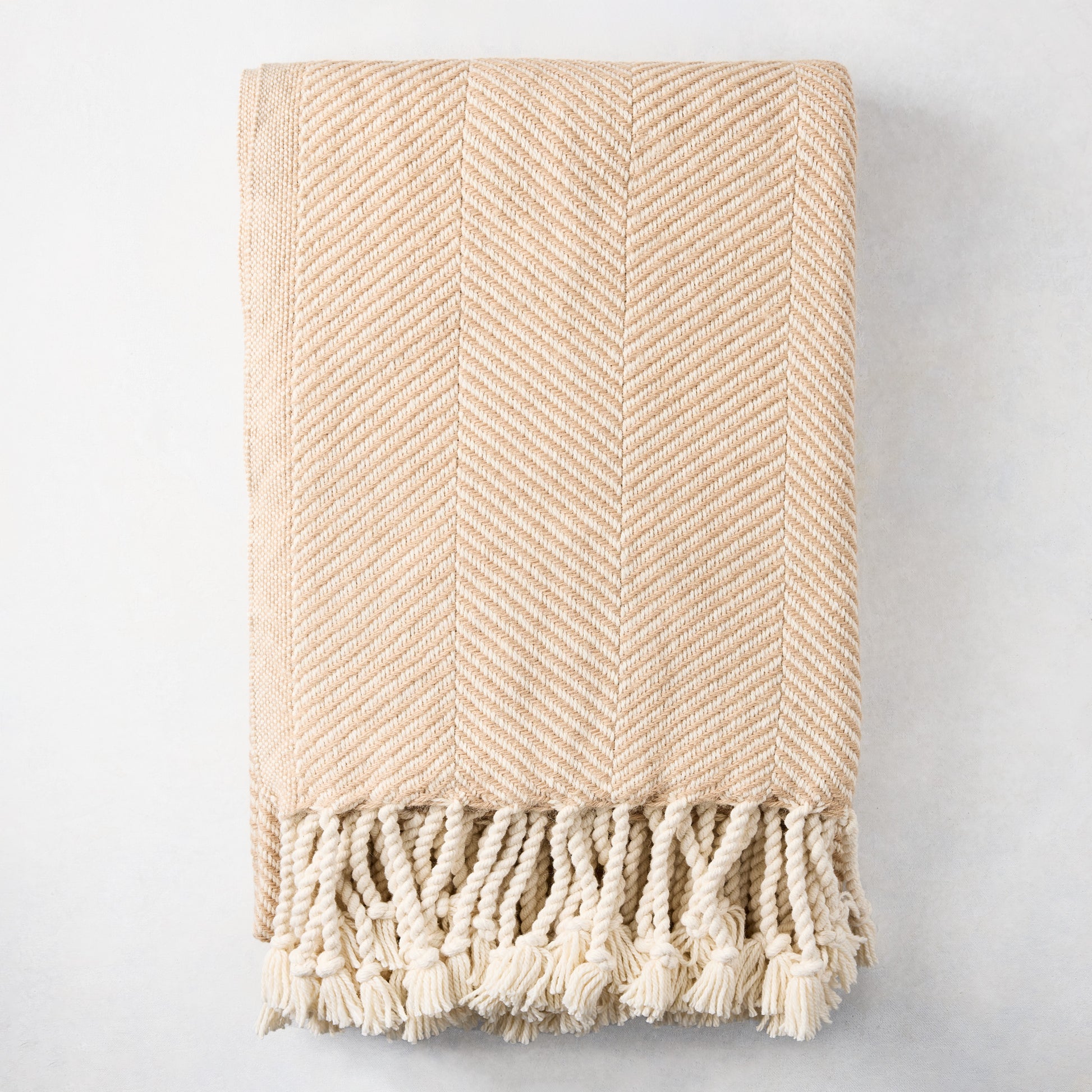 Khaki chevron cotton throw blanket with thick rope fringe.