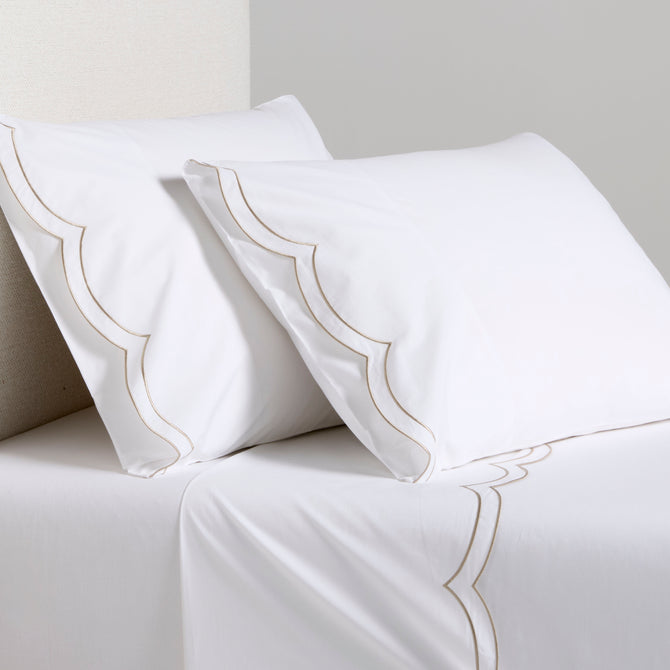 White organic cotton percale sheet set with khaki double scallop stitch embroidery on pillows and top sheet.