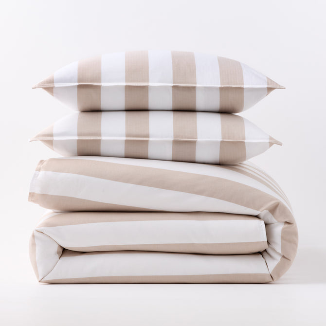 Khaki and white wide-striped duvet cover folded with two matching rectangular pillow shams stacked on top.