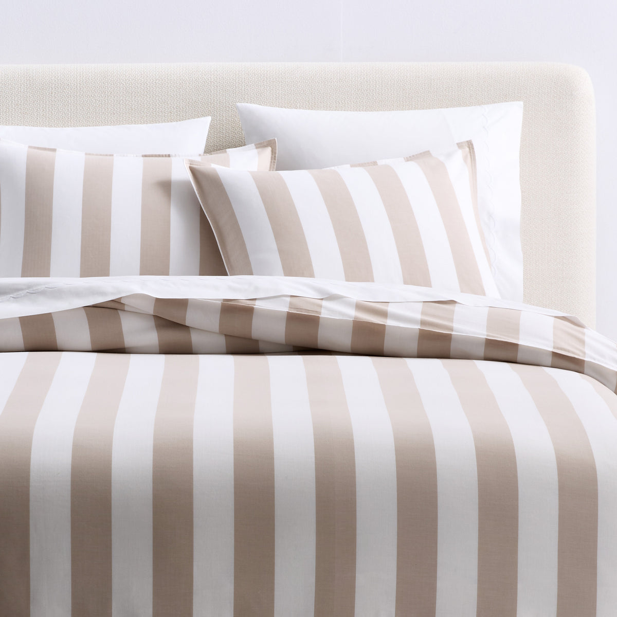 Set of two khaki and white herringbone striped cotton euro shams on a bed.