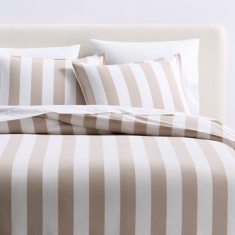 Set of two khaki and white herringbone striped cotton euro shams on a bed.