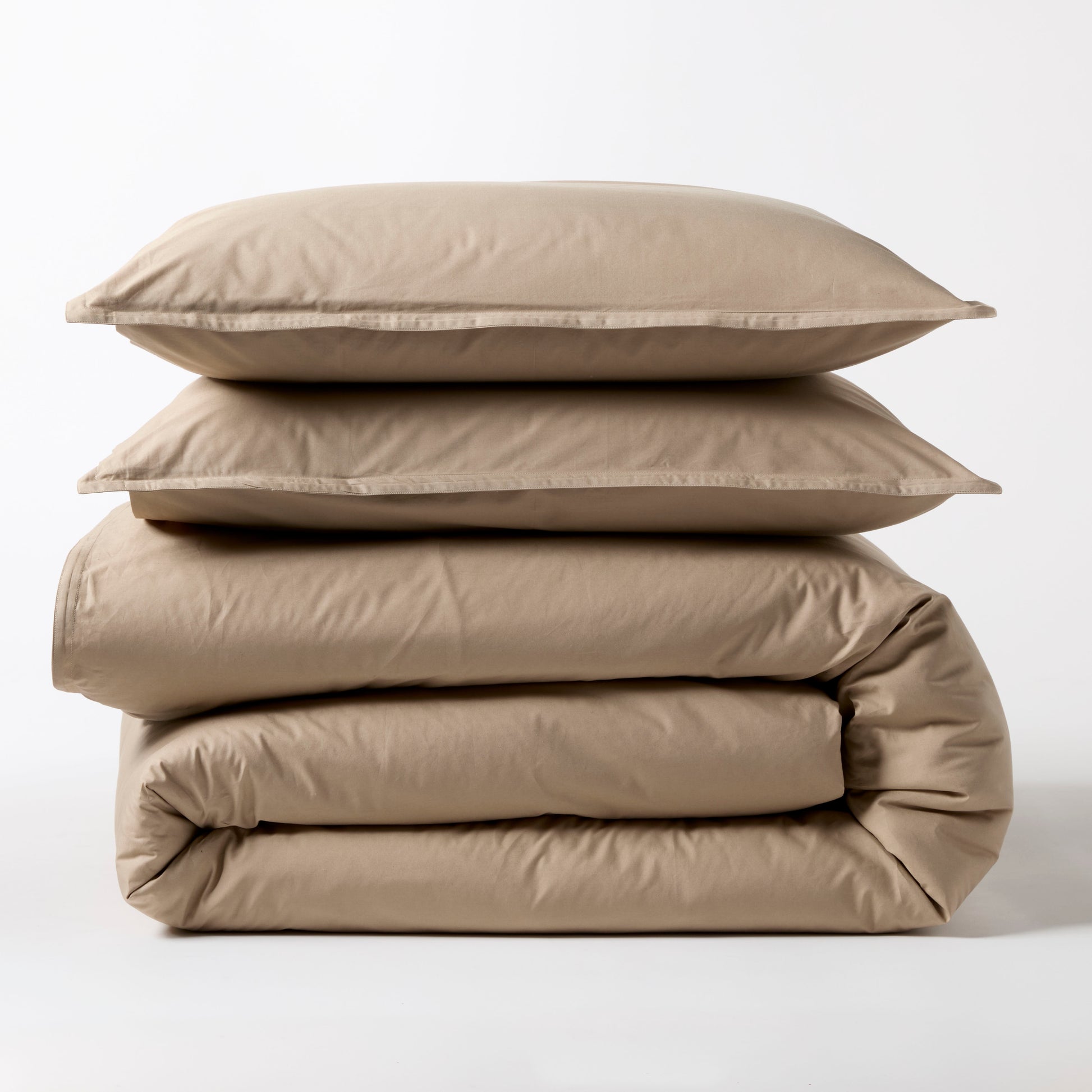 Khaki Italian Percale Duvet Set: two folded duvets and two stacked shams in a neutral beige.
