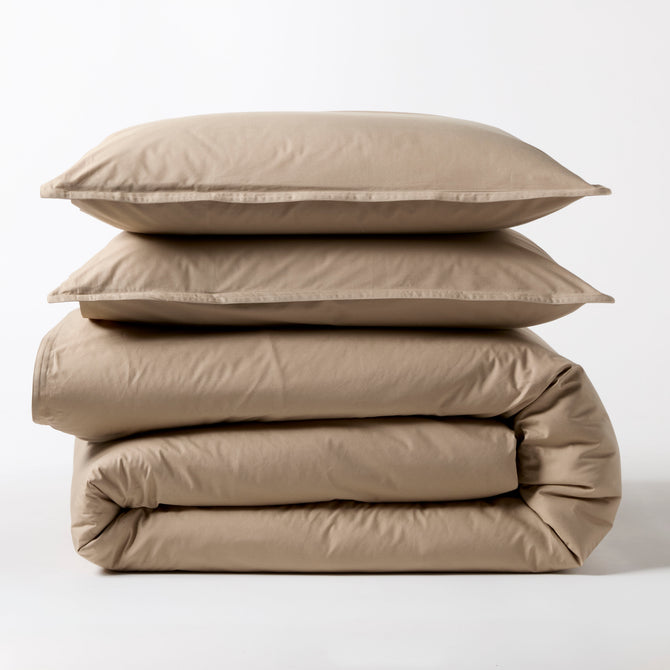 Khaki Italian Percale Duvet Set: two folded duvets and two stacked shams in a neutral beige.