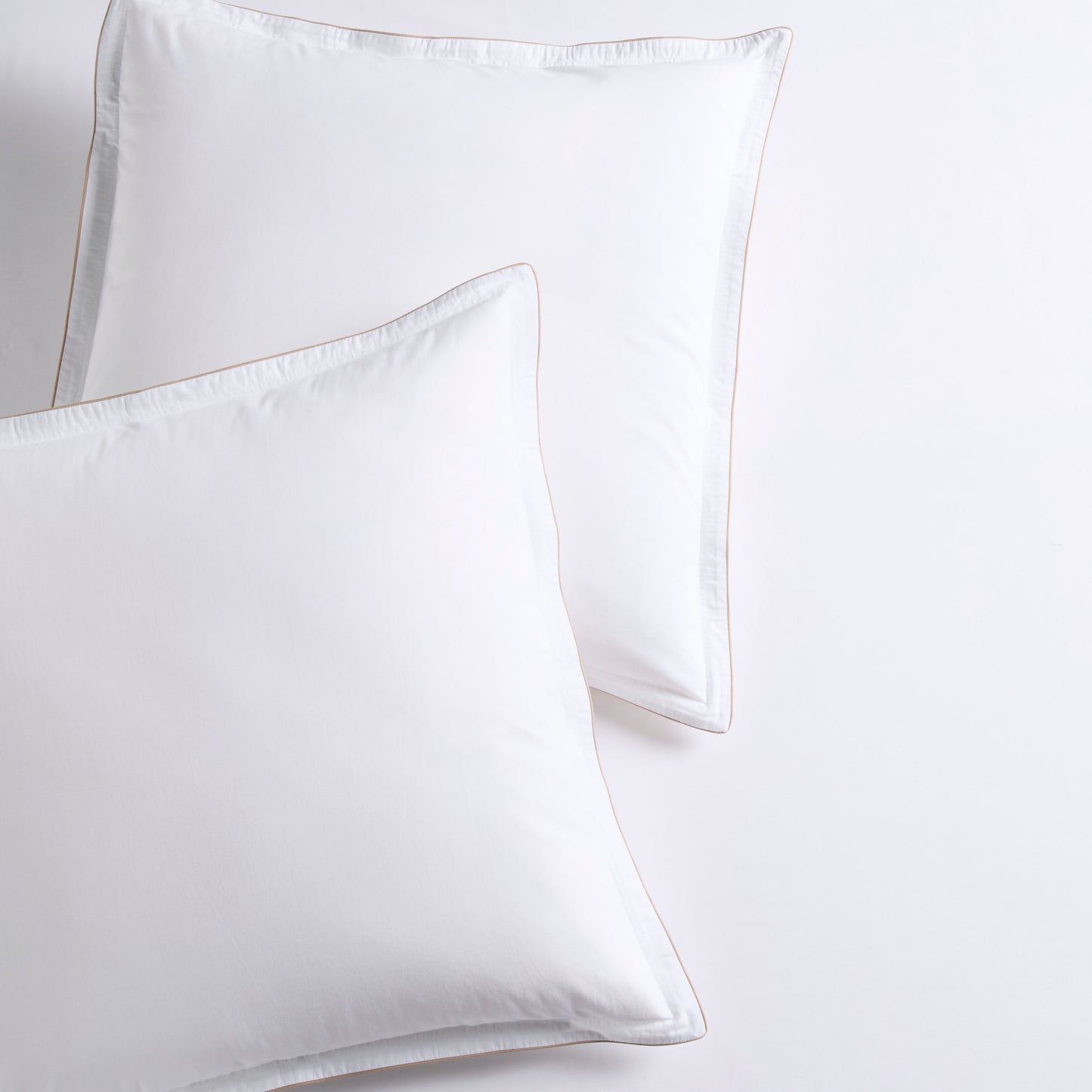 Set of 2 white percale Euro shams with khaki piping and double-stitch detailing.