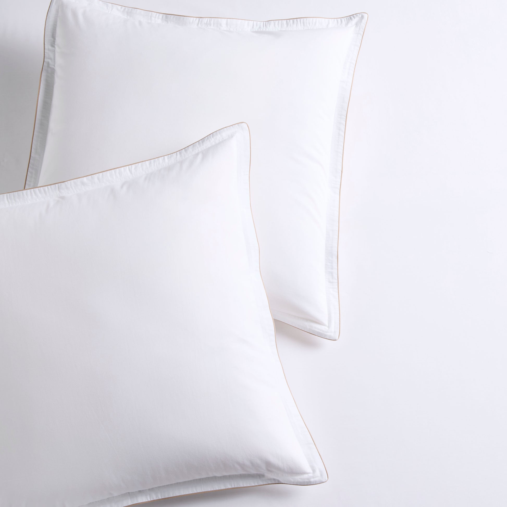Set of 2 white percale Euro shams with khaki piping and double-stitch detailing.