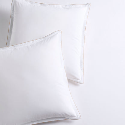 Set of 2 white percale Euro shams with khaki piping and double-stitch detailing.