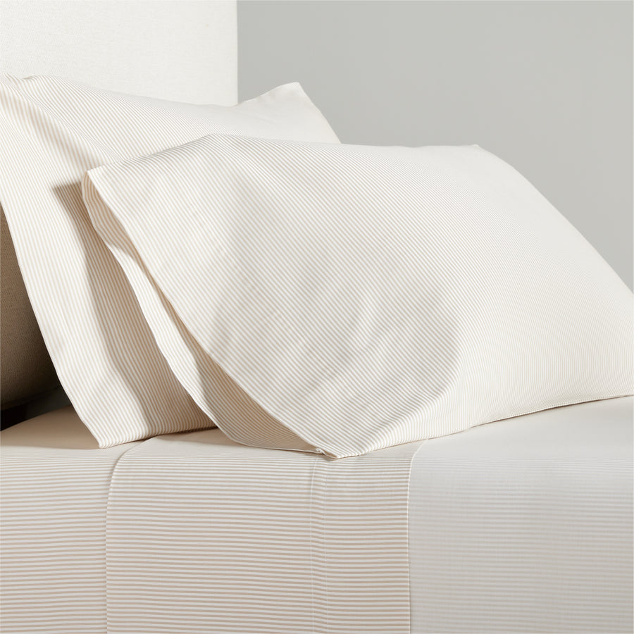 Khaki Stripe Cotton-Chambray Sheet Set with thin woven stripes on pillows and flat sheet.