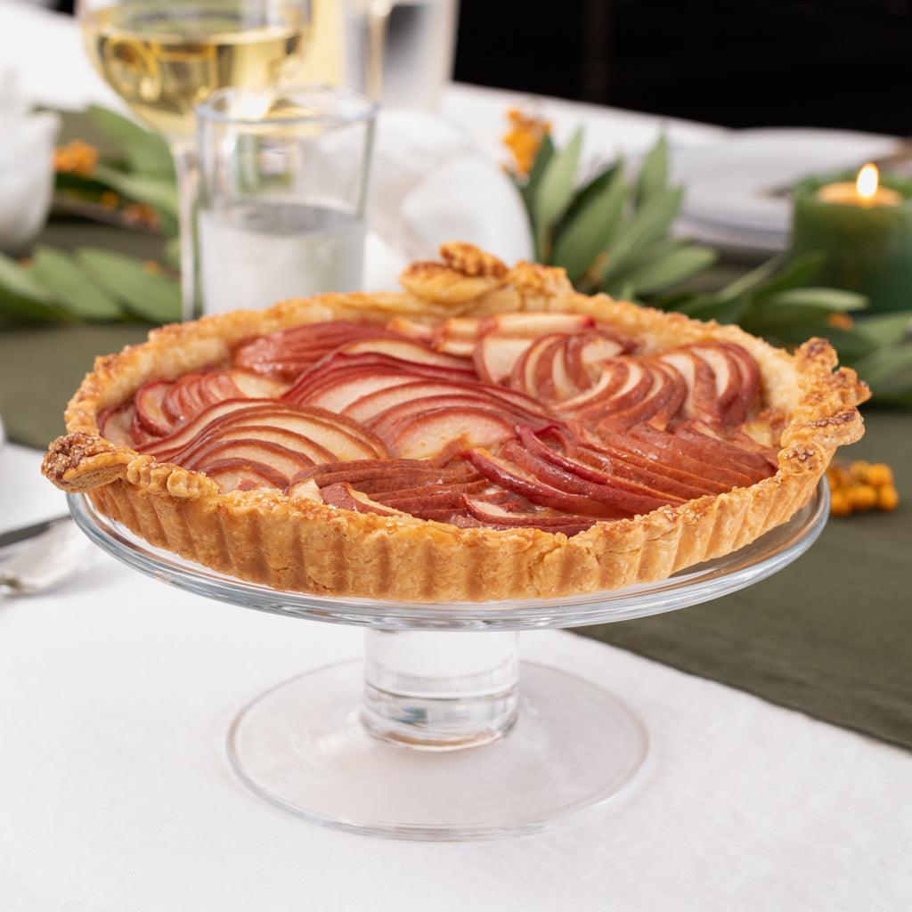 Clear glass Klara Small Cake Stand, 9.5"Dia. x 4"H, holding a pear tart on a dining table.