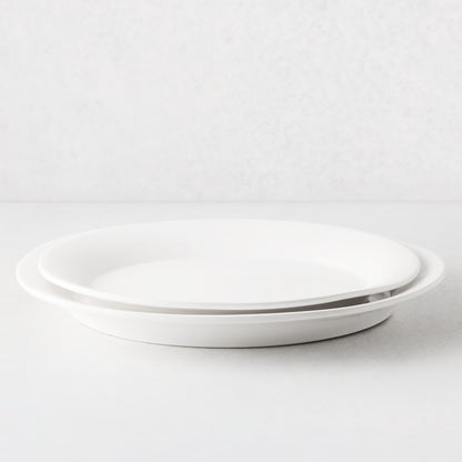 Two stacked Lagos white ceramic serving platters with raised edges.