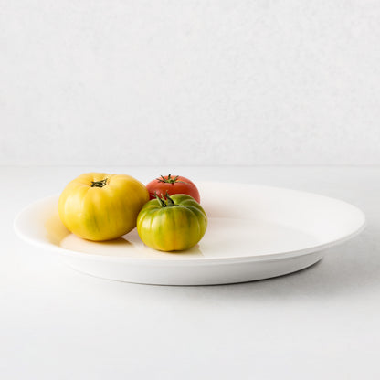 White ceramic Lagos serving platter with three heirloom tomatoes.