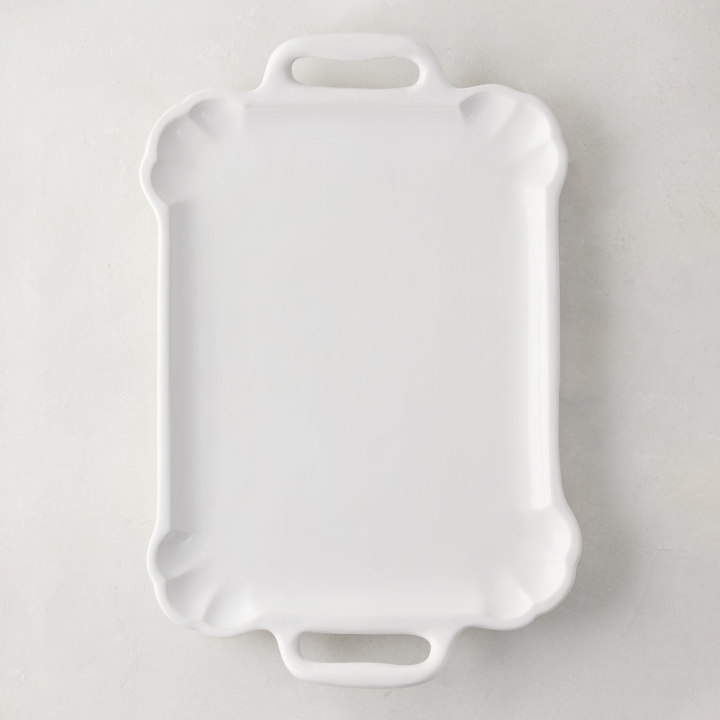 Large Alessia white ceramic handled serving platter with delicate scalloped edges.
