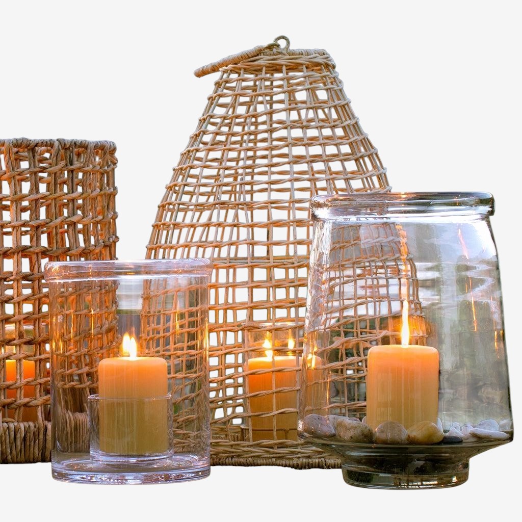 Large clear glass Antwerp Hurricane candle holder with folded edges, holding a lit pillar candle.
