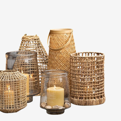 Large clear glass Antwerp Hurricane candle holder with folded edges, holding a cream pillar candle and small stones.