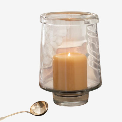 Large clear glass Antwerp Hurricane candle holder with a lit pillar candle.