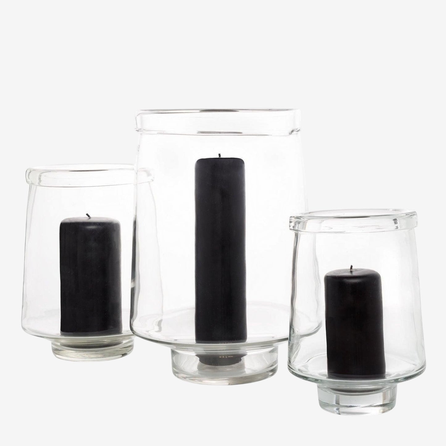Three clear glass Antwerp hurricane candle holders, varying sizes, each with a black pillar candle.