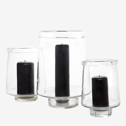 Three clear glass Antwerp hurricane candle holders, varying sizes, each with a black pillar candle.