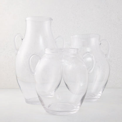 Three clear recycled glass confit vases with decorative handles, varying in size.