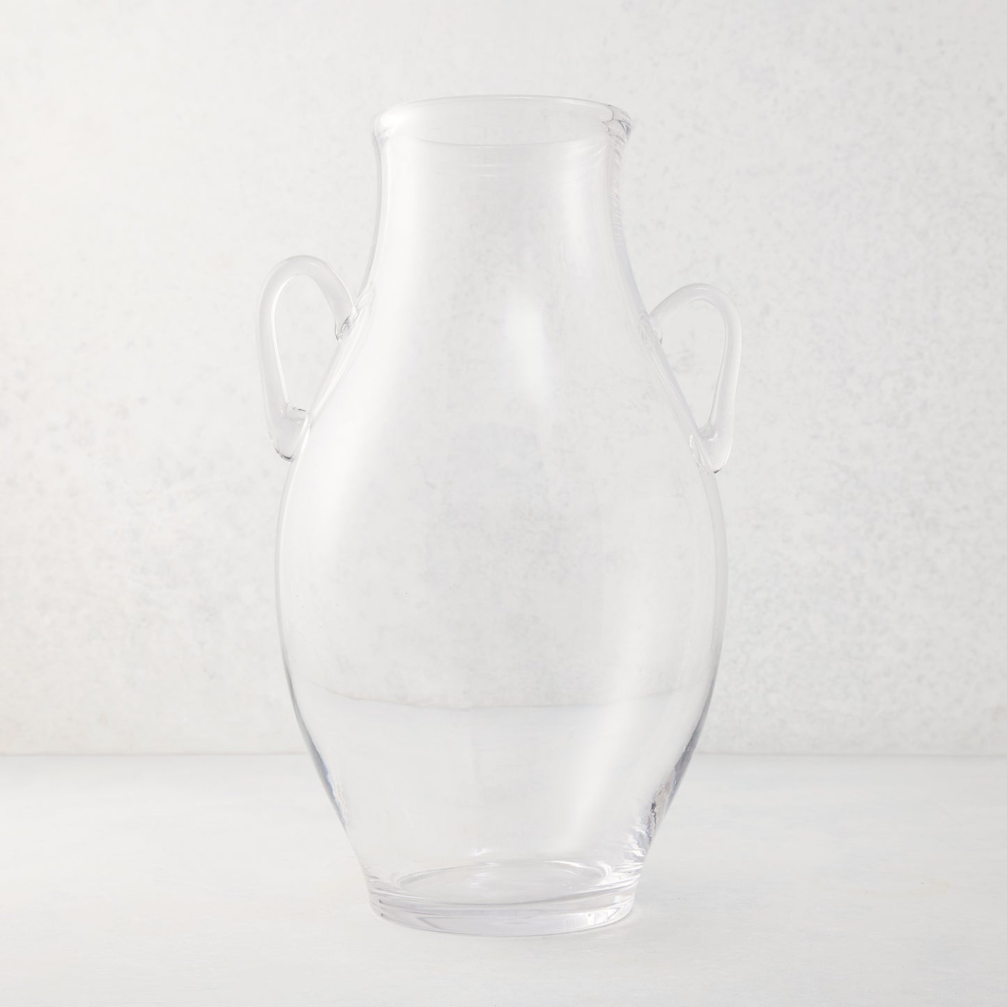 Large clear recycled glass confit vase with organic curves and decorative handles.