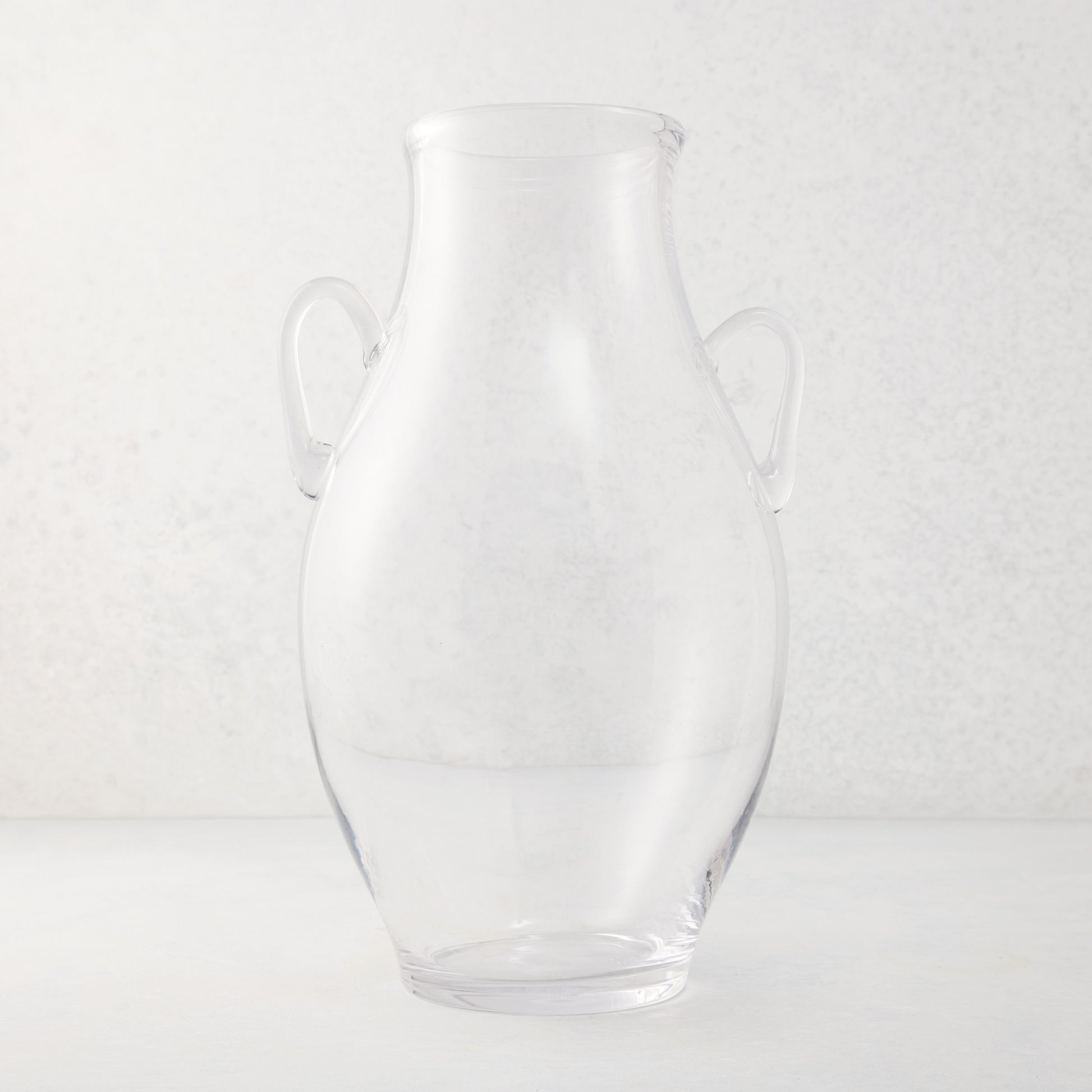 Large clear recycled glass confit vase with organic curves and decorative handles.