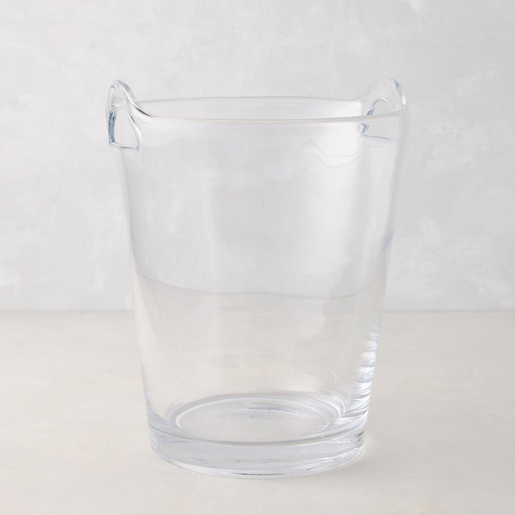 Large clear handblown glass ice bucket with two handles.