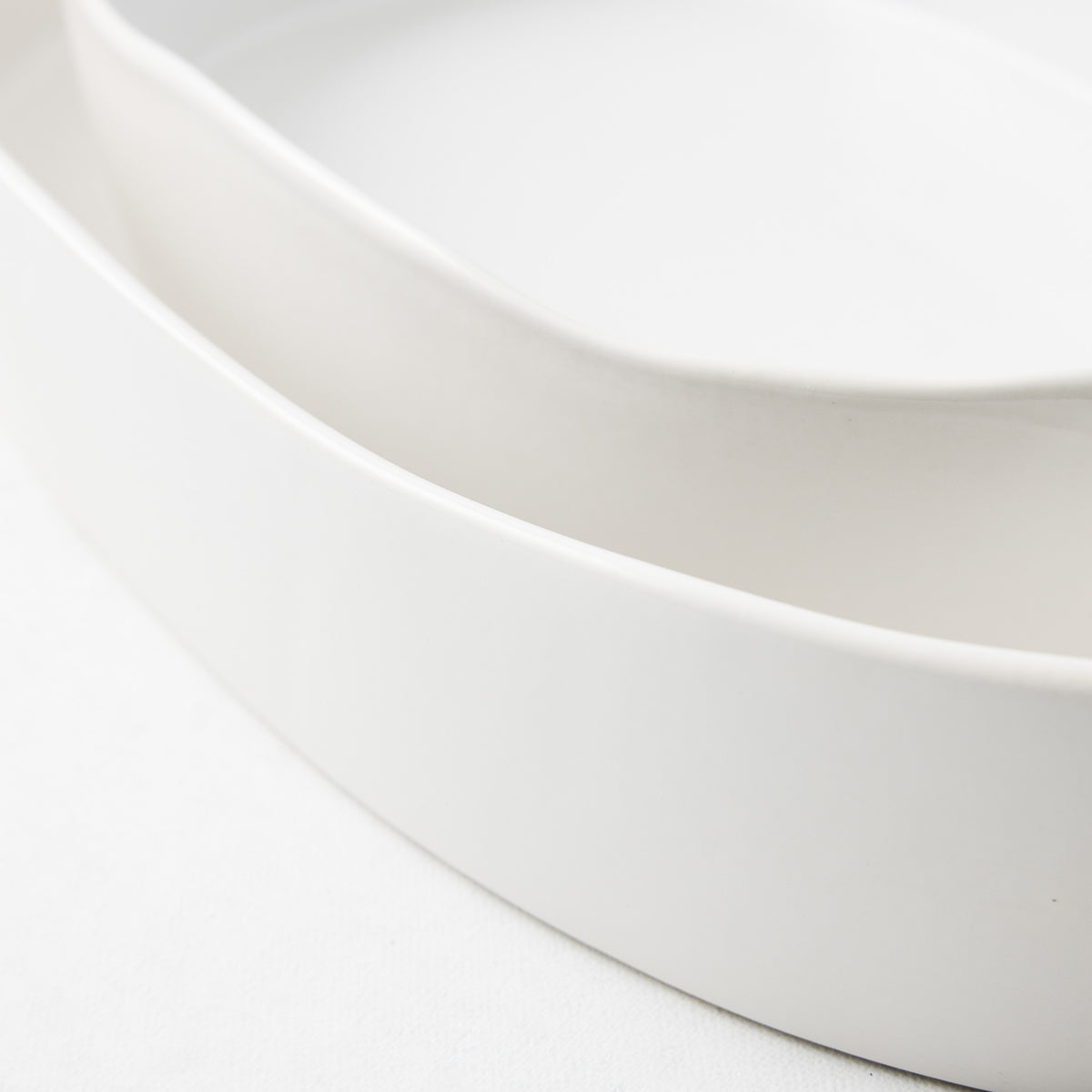 Large oval stoneware baker in matte white with a smooth, minimalist design and curved edges.