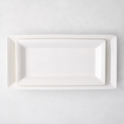 Two white ceramic Lucca rectangular serving platters, one nested inside the other, on a white background.