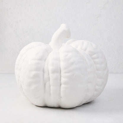 Large matte white ceramic pumpkin, 12"H x 10"Dia, with a short stem and ribbed texture.