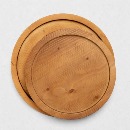 Two round natural reclaimed pine wood serving trays, one large and one small, with raised rims.