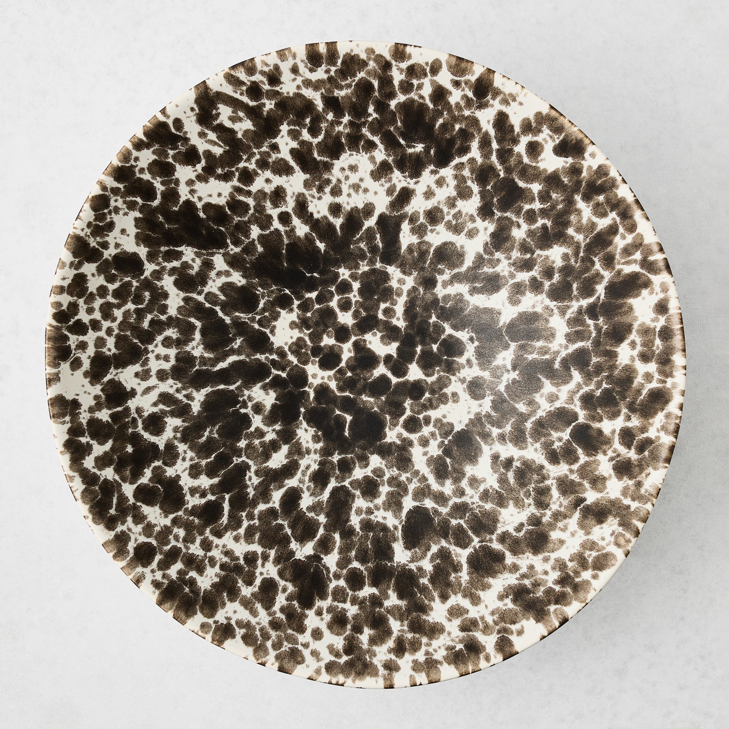 Large Nuno Splatter stoneware serve bowl with brown spots on a pale cream base.