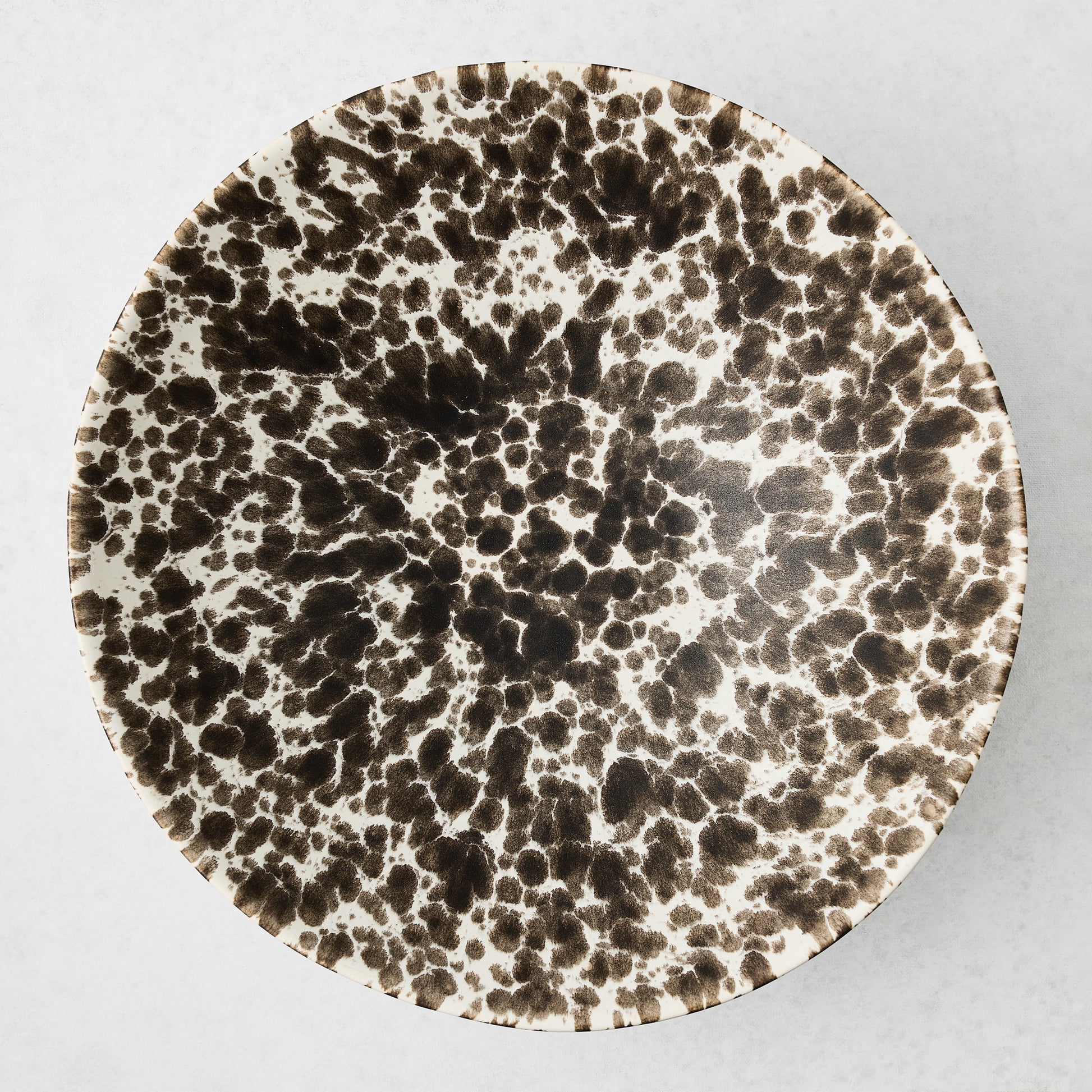 Large Nuno Splatter stoneware serve bowl with brown spots on a pale cream base.