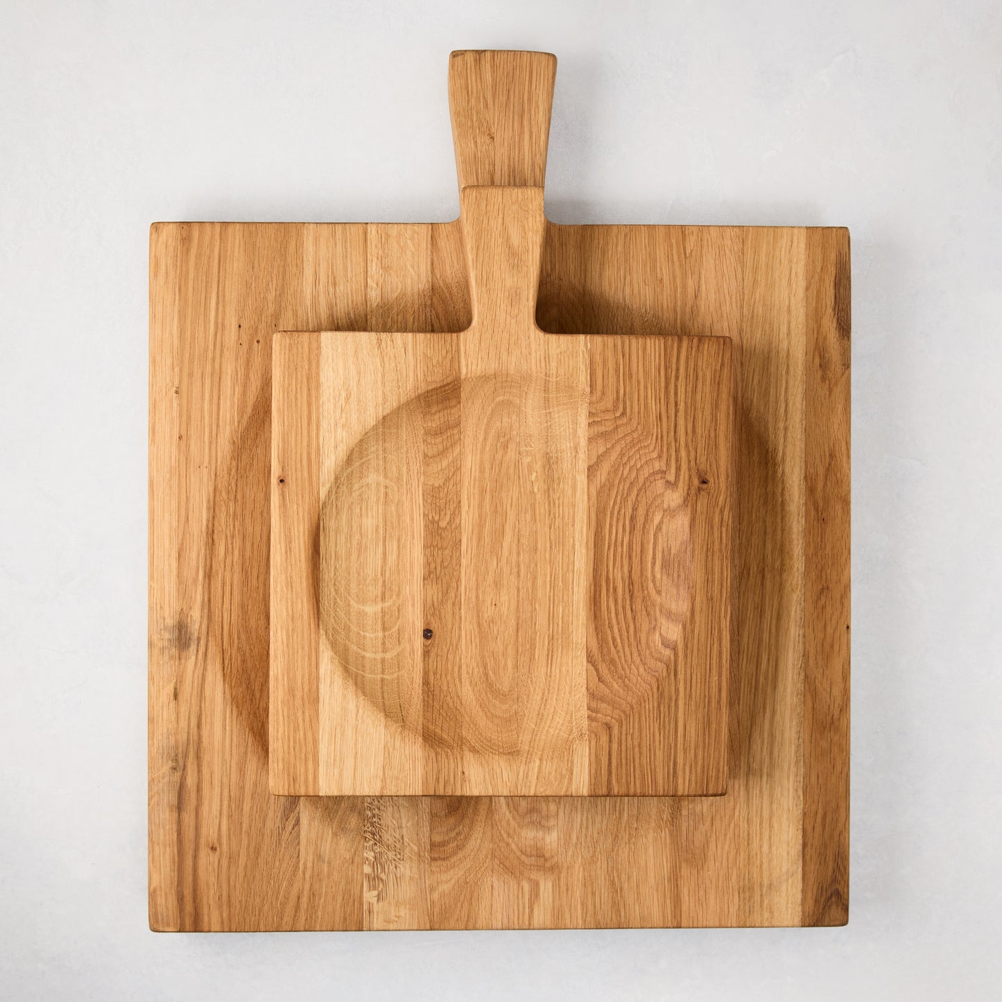 Large reclaimed oak wood cutting board bowl with a smaller handled board and curved mezzaluna blade.