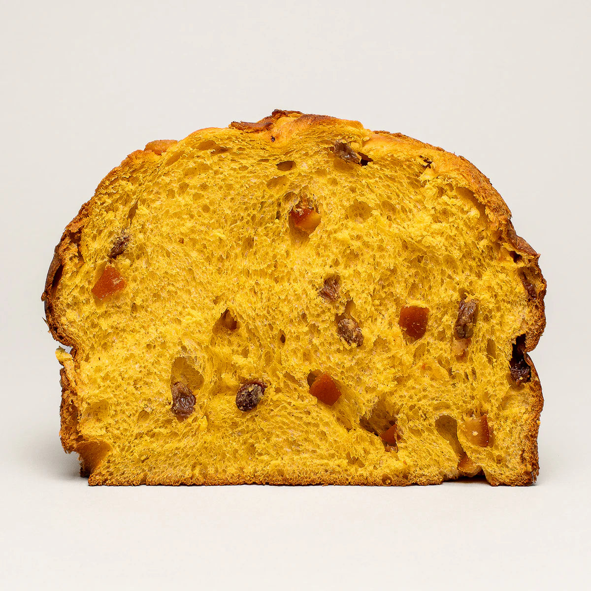 Slice of golden-yellow Olivieri classic panettone with visible raisins and candied orange pieces on a white background.