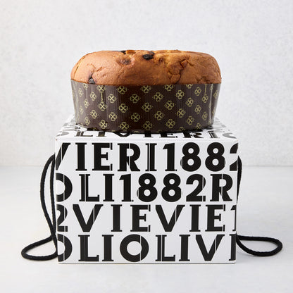 Large Olivieri classic panettone in a brown paper mold with gold clover patterns, resting on a branded white and black gift box.